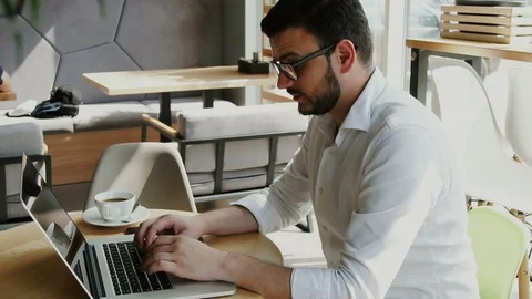 Bearded man in formal clothes and with glasses working in cafe and having coffee Stock Footage 112986262