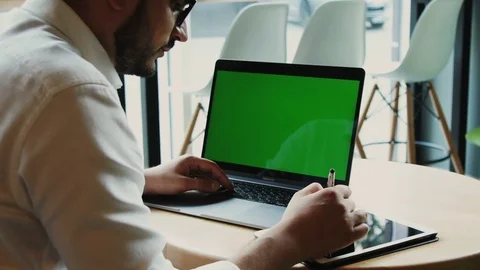 Bearded man in formal shirt using chroma key screen of computer and drawing on Stock Footage 112994195