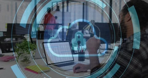 Bearded man gesturing at laptop in tech office, activating cloud padlock HUD Stock Footage 330602541