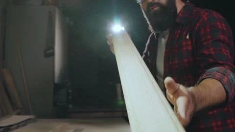 Bearded man in glasses blows dust off a wooden product, slow motion. Stock Footage 131563645