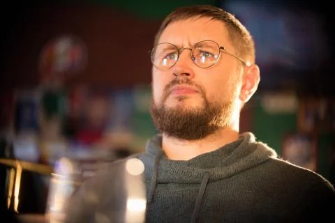 Bearded man in glasses looking perplexity. Irish pub Stock Photos
