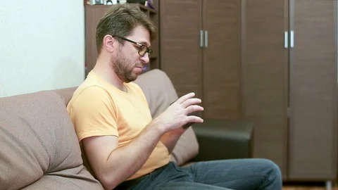 A bearded man with glasses measures his blood pressure. Stock Footage 100582579