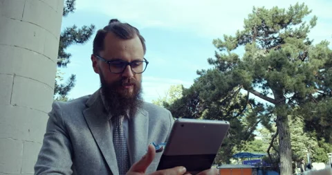Bearded man with glasses sitting at the table of a cafe on the outdoor terrace. Stock Footage 139206353
