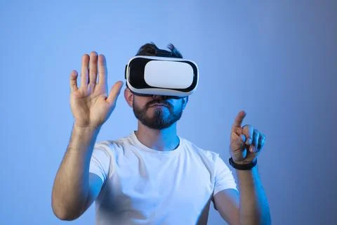 Bearded man with glasses of virtual reality in a neon light. Future technology Stock Photos