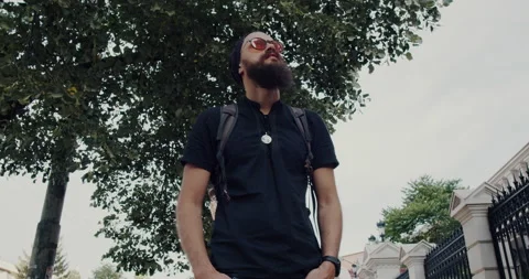 A bearded man with glasses walks down the street. Stock Footage 139284555