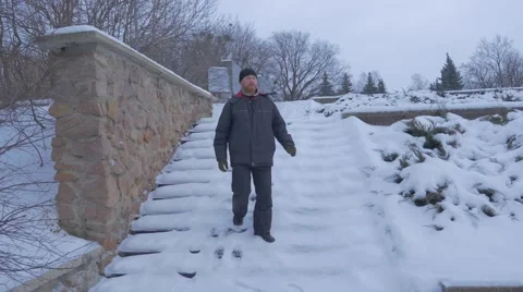 A Bearded Man Going Down a Snowy Winter Staircase, and Moving to Artyom Stock Footage 58994943