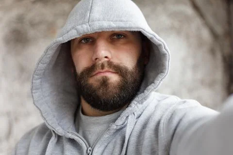 Bearded man on a gray background makes a selfi Stock Photos