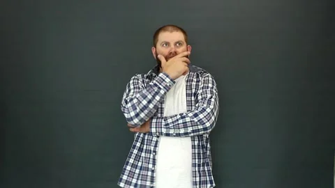 Bearded man on a gray background pondered and put his hand to his chin Video stock 157859666