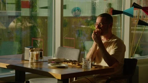 A bearded man with great appetite eats pizza and enjoys it in a restaurant Stock Footage 244084934