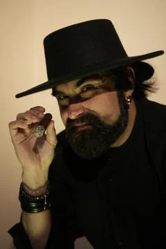 A bearded man in a hat with a lit cigar in his hand Foto stock