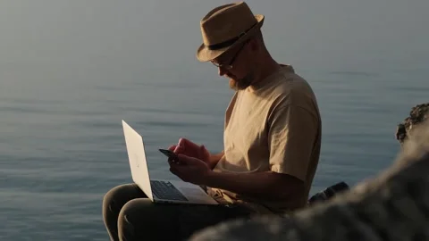 Bearded man in hat working outdoor. Digital nomad and solo travel concept. Stock Footage 253973991