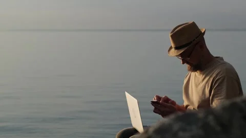 Bearded man in hat working outdoor. Digital nomad and solo travel concept. Stockbeeldmateriaal 257289291