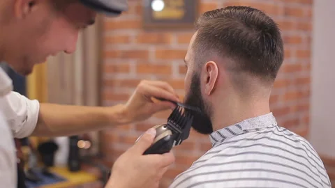 Bearded man having his beard cut by hairdresser at the barbershop Video stock 93712101