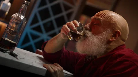 Bearded man in his 50s drinks alcohol before driving home, serious DUI risk Stock Footage 346714158
