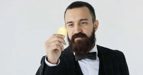 Bearded man holding bitcoin in his hand white background Stock Footage 79752919