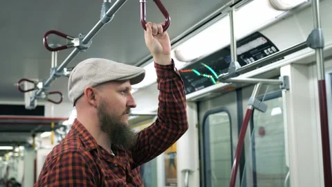 Bearded man holding handle on moving train Close-up of bearded millennial man in Vidéo 253534668