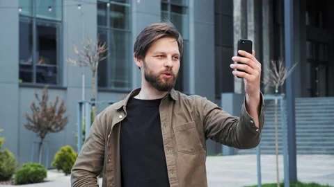 Bearded man holding using smartphone app having video call outdoor. Video stock 154638113