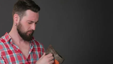 Bearded man inspects the sharpness of his trusty ax Stock Footage 311826349