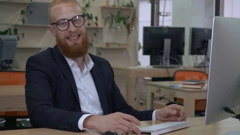 Bearded man laughs in office Stock Footage 83241728