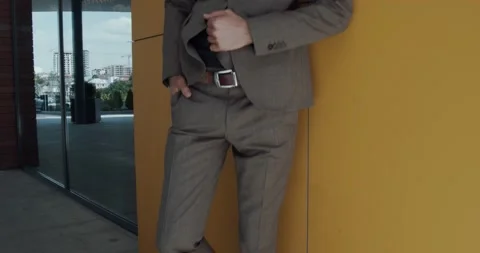 Bearded man, with a light brown suit, leaning on the wall Stock Footage 142394641