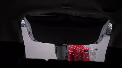 Bearded man loading the baggage compartment of the car with bags Stock Footage 71061888