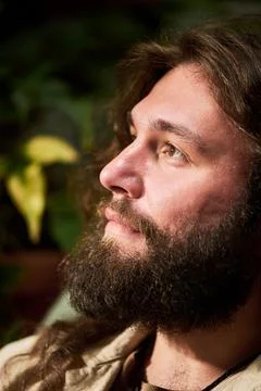 Bearded Man Looking Away Thoughtfully in Nature Fotos de archivo