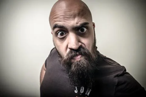 Bearded man looking camera with funny strange expression Stock Photos