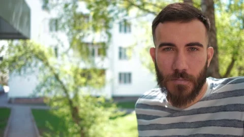 Bearded man looking at camera standing on the street. portrait. summer. spring Stock Footage 141192695