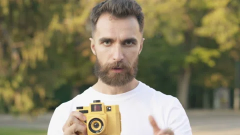 Bearded man looking at the camera, talking like with model and taking pictures. Stock Footage 115631663