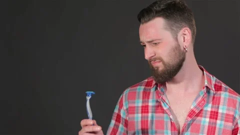 Bearded man looks at the shaver Stock Footage 251464257