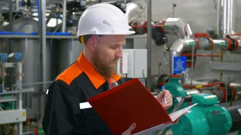 A bearded man, a mechanical engineer in a white helmet, makes an audit of Stock Footage 170705100