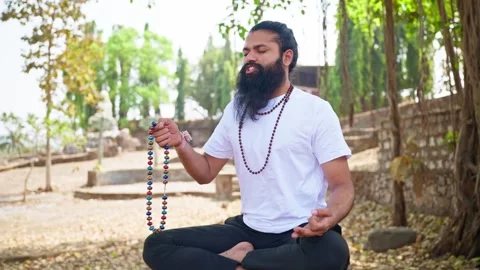 Bearded man meditates beneath trees at retreat Stock Footage 303127865