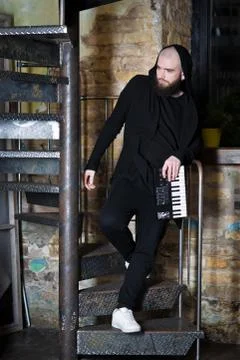 A bearded man with a mini piano. Stock Photos