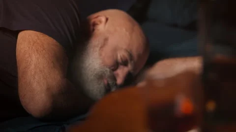 Bearded man naps after heavy drinking, facing midlife crisis and alcoholism Stock Footage 346714331