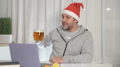 Bearded man in a New Year's hat congratulates friends on the computer Stock Footage 167949072
