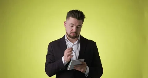 Bearded man in office suit thinks and takes notes in paper notebook having idea. Stock Footage 149108276