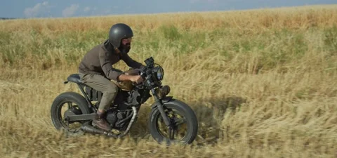 Bearded man on old cafe racer motorcycle in wheat field Stock Footage 140622265