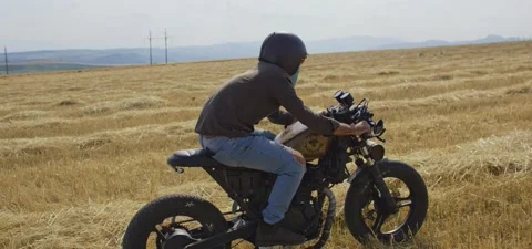 Bearded man on old cafe racer motorcycle in wheat field Stock Footage 140622396