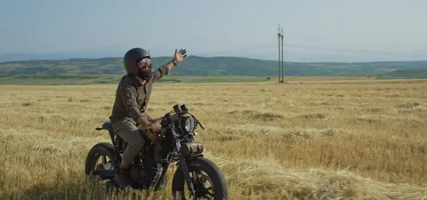 Bearded man on old cafe racer motorcycle in wheat field Stock Footage 140622504