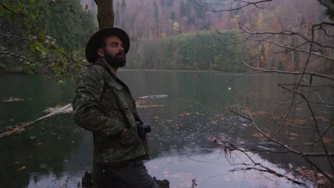 Bearded man with old camera in autumn forest near a lake Stock Footage 138122693