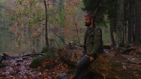 Bearded man with old camera in autumn forest near a lake Video stock 138123134