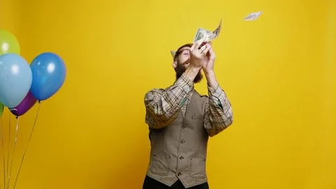 Bearded man in party hat catches dollars Video stock 81698464