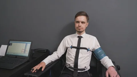 Bearded man passing check on polygraph machine in office Stock Footage 122627412