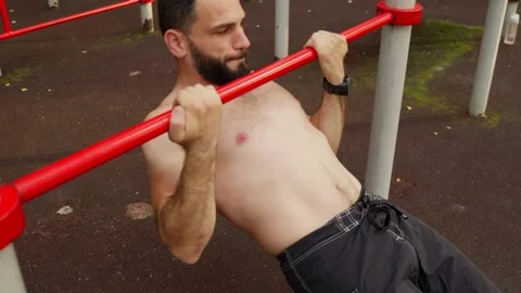 Bearded Man Performs Inverted Rows at Outdoor Gym Video stock 329599254