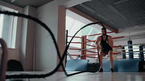 The bearded man performs a sports exercise with fighting ropes. Intense Stock Footage 156865523