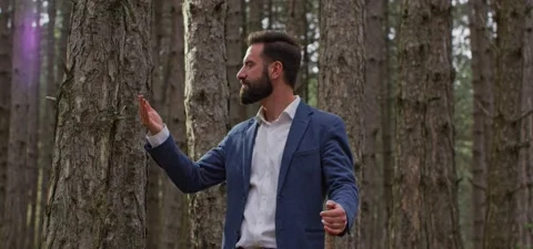 Bearded man in pine forest, smells pine resin Stock Footage 140267595
