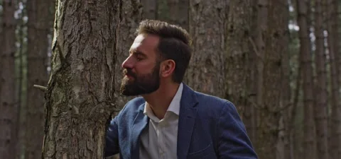 Bearded man in pine forest, smells tree Stock Footage 140268002