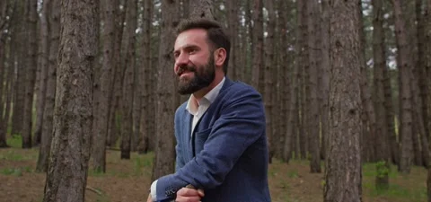 Bearded man in pine forest, standing and enjoying air Stock Footage 140265978