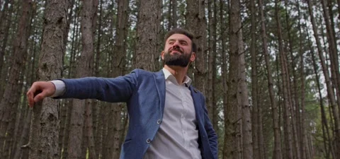 Bearded man in pine forest, standing and enjoying air Stock Footage 140267024