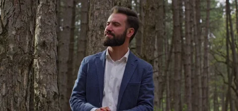 Bearded man in pine forest, thinks and enjoying air Stock Footage 140267646